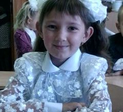 Юля за партой в классе.